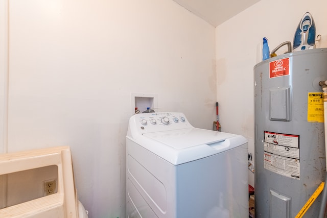 clothes washing area featuring water heater and washer / dryer