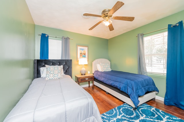 bedroom with dark hardwood / wood-style floors and ceiling fan