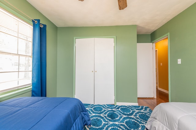 bedroom featuring a closet, dark wood-type flooring, and ceiling fan