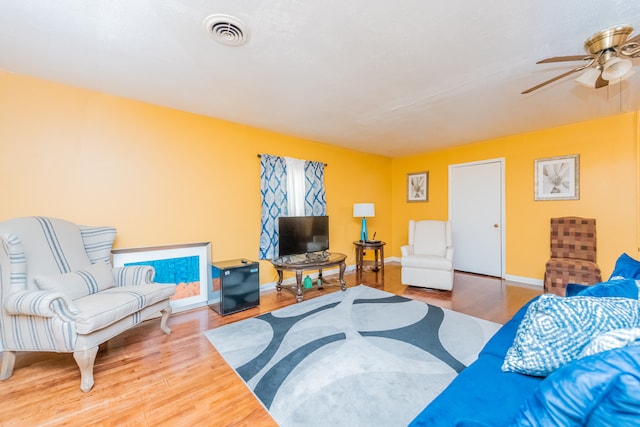 living room with light hardwood / wood-style flooring and ceiling fan