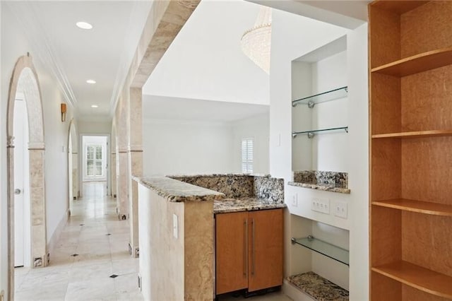 interior space featuring crown molding, dark stone counters, and light tile floors