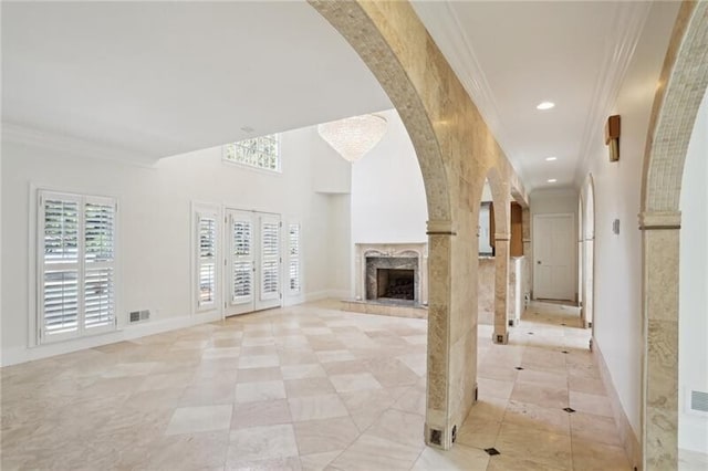 unfurnished living room with light tile flooring and ornamental molding