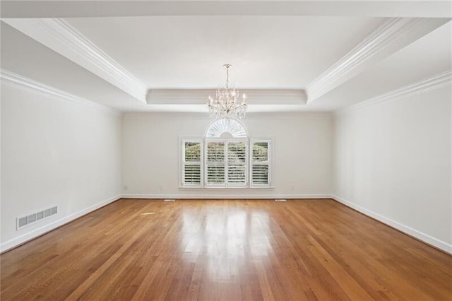 unfurnished room with a chandelier, a tray ceiling, and hardwood / wood-style flooring