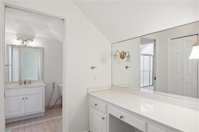 bathroom featuring tile floors, toilet, oversized vanity, and vaulted ceiling