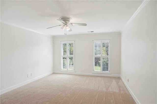 carpeted empty room with crown molding, ceiling fan, and a wealth of natural light