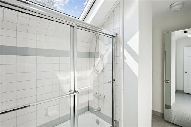 bathroom with enclosed tub / shower combo, lofted ceiling with skylight, and tile flooring