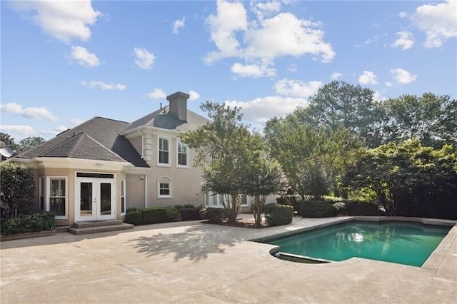 view of swimming pool featuring a patio area and french doors