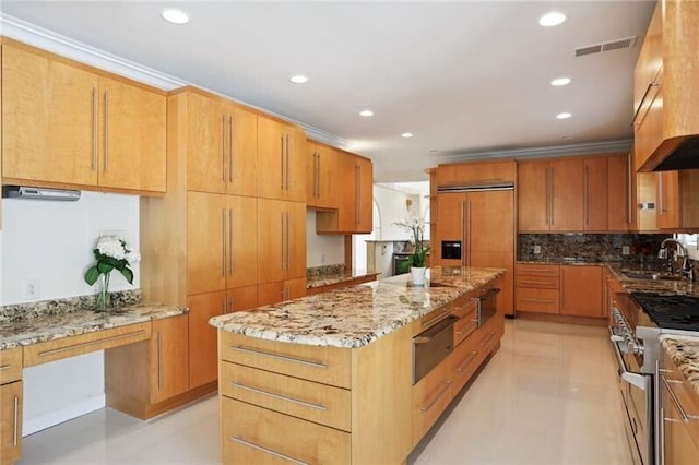 kitchen with light stone countertops, sink, light tile floors, a kitchen island, and high quality appliances