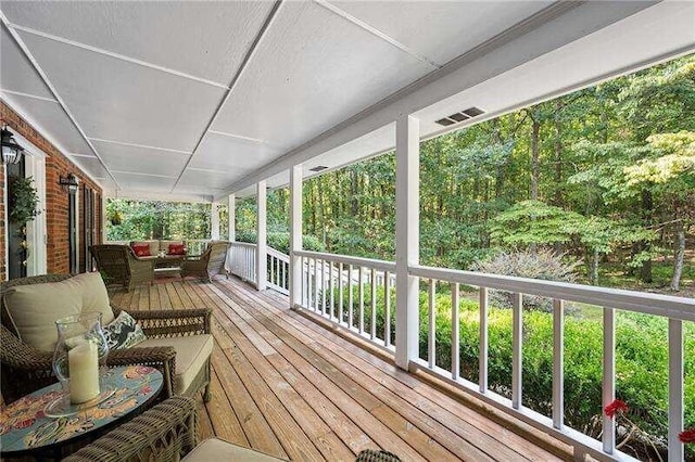 deck with outdoor lounge area and covered porch