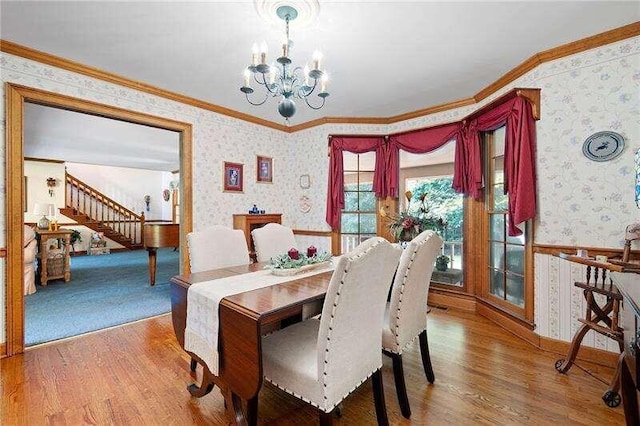 dining room with an inviting chandelier, crown molding, and wood-type flooring