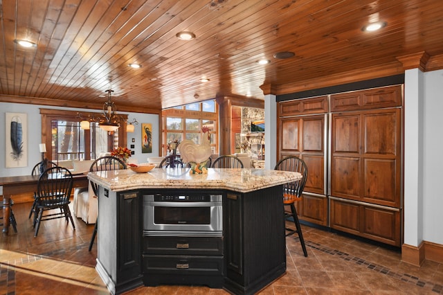 686 Lake Dr, Morganton, GA 30560 - kitchen with an island with sink, a breakfast bar, wood ceiling, light stone countertops, and stainless steel oven