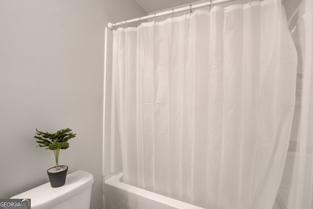 bathroom with shower / bath combo and toilet