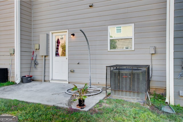 entrance to property featuring central AC unit and a patio area