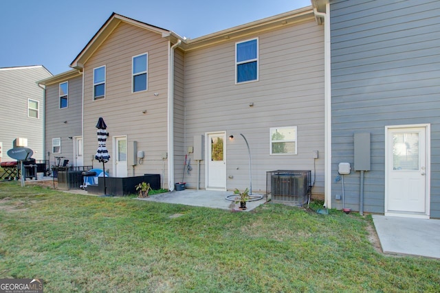 rear view of house with a patio, a yard, and central AC