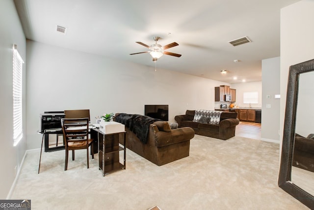 living room featuring light colored carpet and ceiling fan