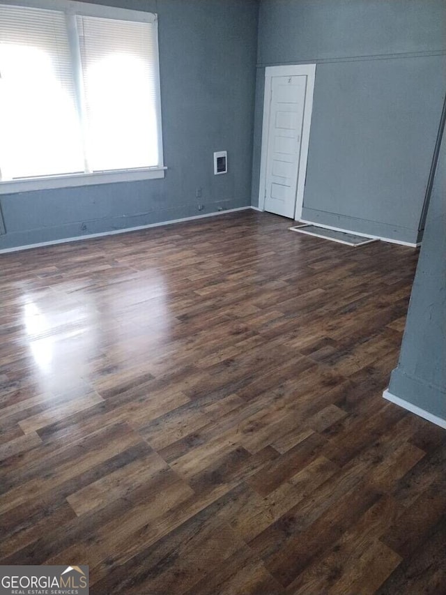 empty room with dark hardwood / wood-style flooring