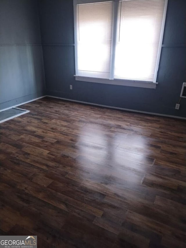 empty room with dark hardwood / wood-style flooring