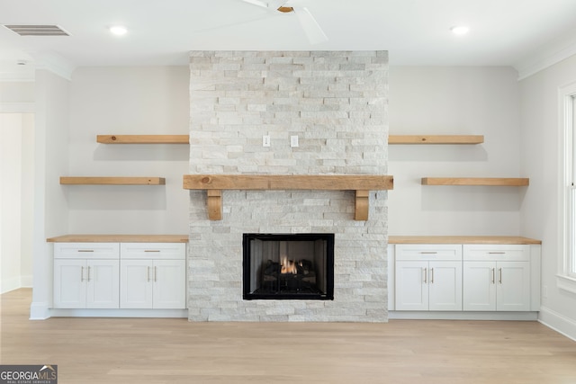 unfurnished living room featuring a stone fireplace and light hardwood / wood-style floors