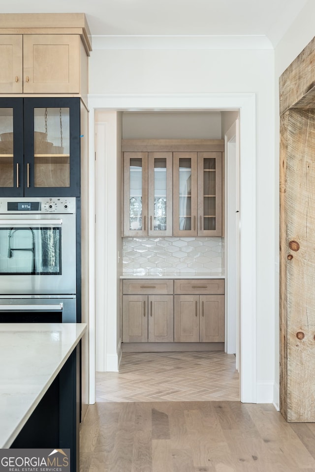 interior space with double oven, decorative backsplash, light hardwood / wood-style floors, and light brown cabinets