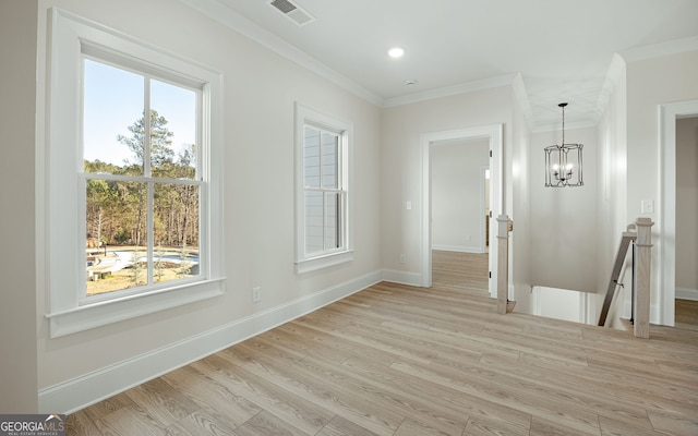 empty room with crown molding, a wealth of natural light, and light wood-type flooring