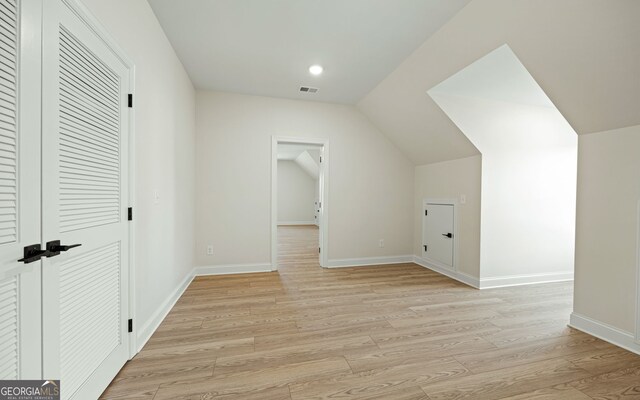 bonus room featuring vaulted ceiling and light wood-type flooring