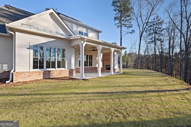 rear view of house with a yard and ceiling fan