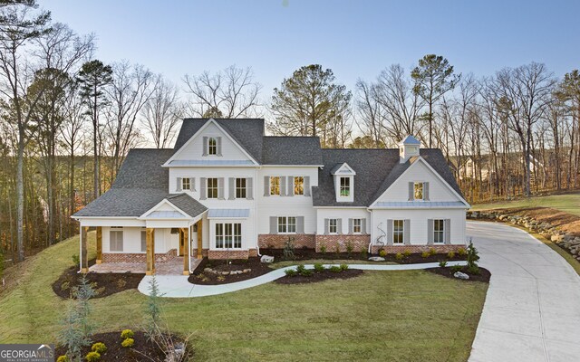 view of front of property featuring covered porch and a lawn