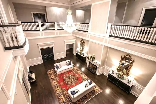 living room featuring a notable chandelier, dark hardwood / wood-style floors, and a high ceiling