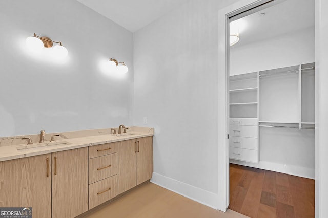 bathroom featuring dual bowl vanity and wood-type flooring