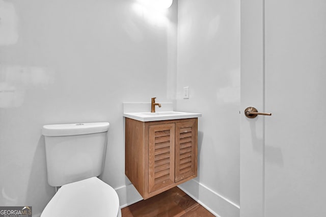 bathroom featuring hardwood / wood-style flooring, toilet, and vanity