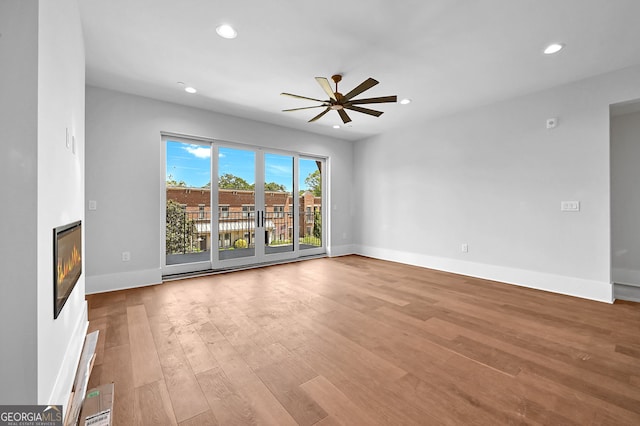 unfurnished living room featuring ceiling fan and light hardwood / wood-style flooring