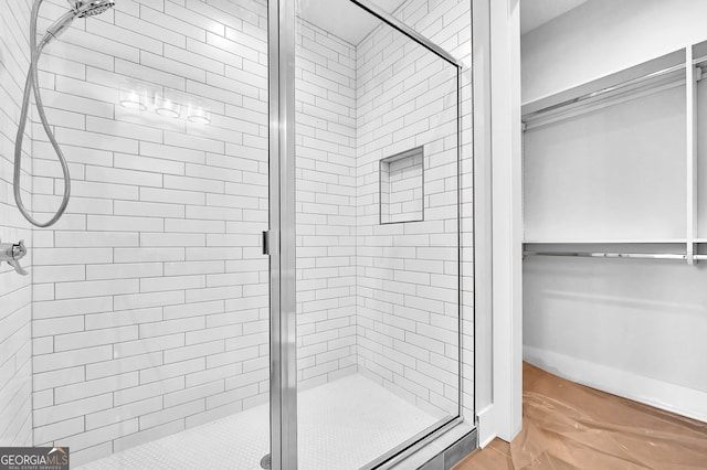 bathroom featuring a shower with shower door