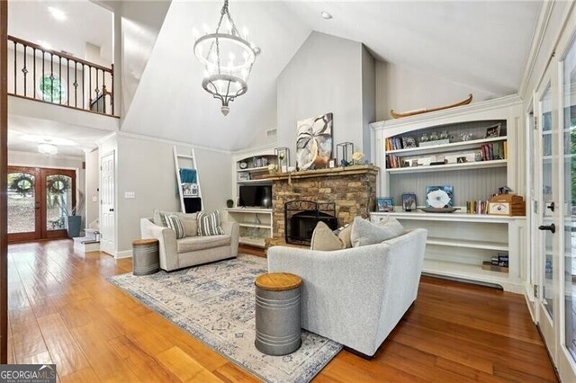 living room with a fireplace, french doors, wood-type flooring, and a healthy amount of sunlight