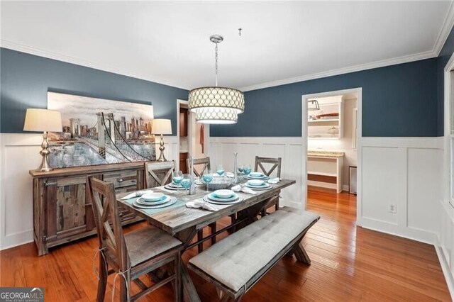 dining space with crown molding and hardwood / wood-style flooring