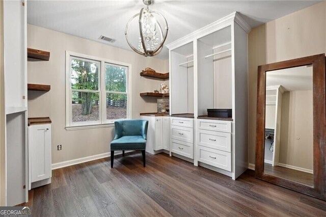 sitting room featuring a chandelier and dark wood-type flooring