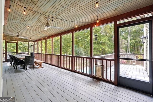 unfurnished sunroom featuring wooden ceiling and ceiling fan