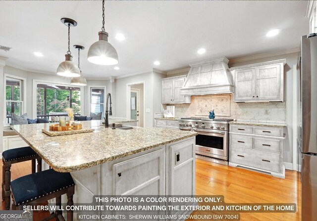 kitchen featuring appliances with stainless steel finishes, tasteful backsplash, light hardwood / wood-style floors, a kitchen island with sink, and custom exhaust hood