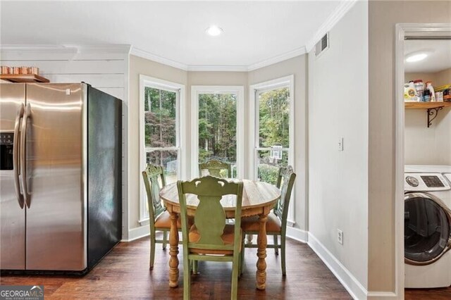 dining area featuring washer / dryer, dark hardwood / wood-style flooring, and ornamental molding