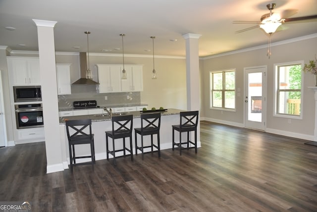 kitchen with backsplash, dark hardwood / wood-style floors, wall chimney exhaust hood, stone countertops, and stainless steel appliances