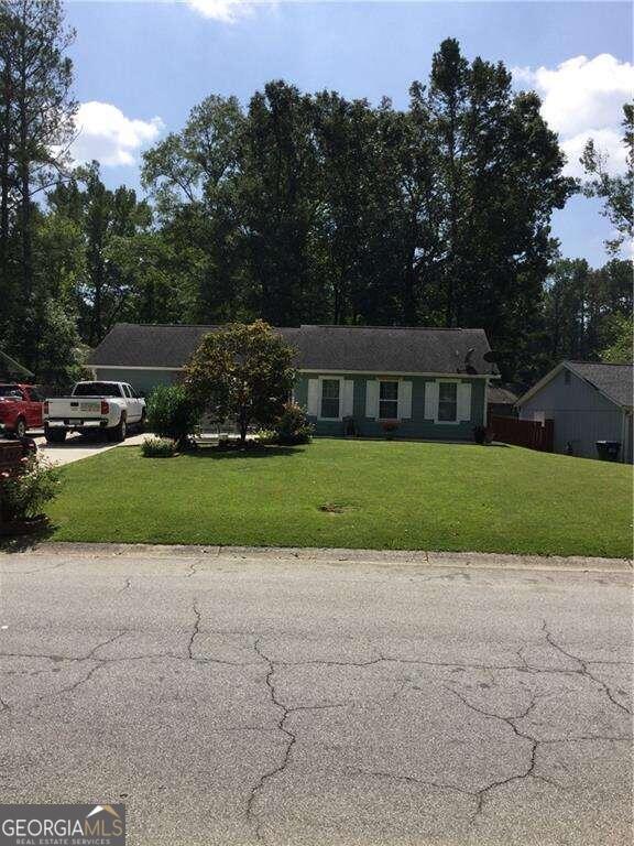 single story home featuring a front lawn