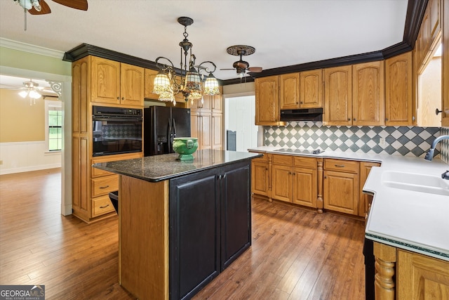 kitchen with a kitchen island, ceiling fan with notable chandelier, tasteful backsplash, dark wood-type flooring, and black appliances