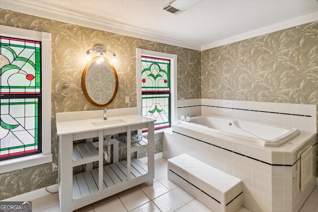 bathroom with crown molding, tiled tub, tile flooring, sink, and a textured ceiling