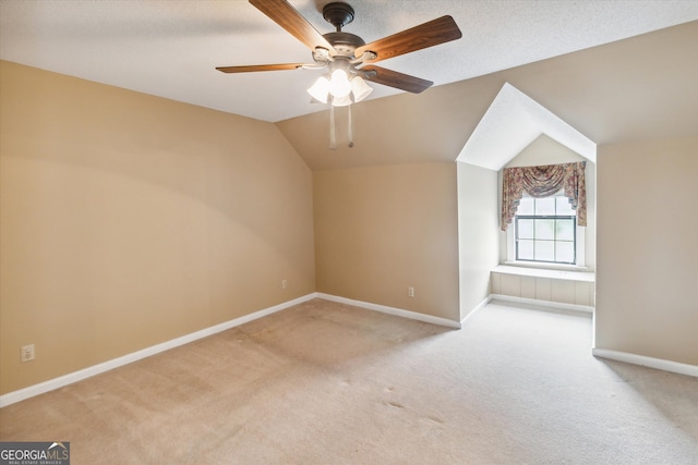 additional living space featuring light carpet, ceiling fan, and vaulted ceiling