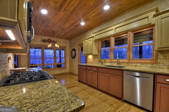 kitchen featuring an inviting chandelier, light stone countertops, appliances with stainless steel finishes, sink, and light wood-type flooring