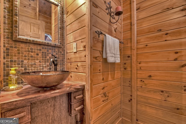 bathroom with backsplash, wooden walls, and vanity