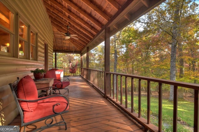 wooden terrace featuring a yard and ceiling fan