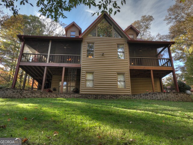 back of house with a lawn and a sunroom