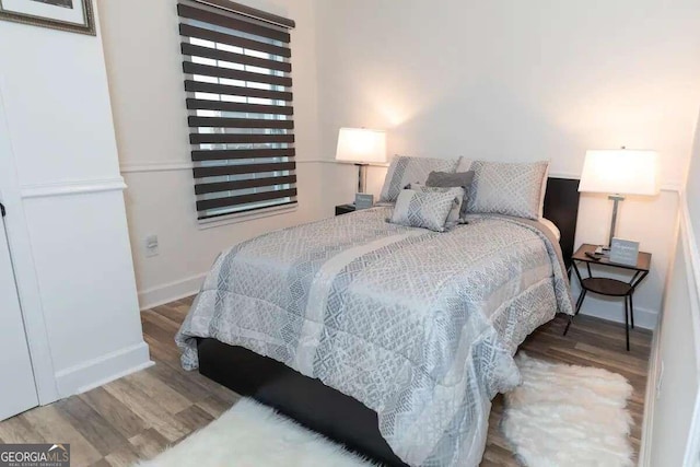 bedroom with dark wood-type flooring