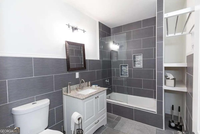 bathroom featuring tile floors, toilet, and tile walls