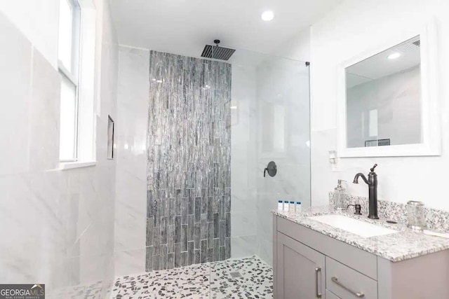 bathroom with vanity and tiled shower